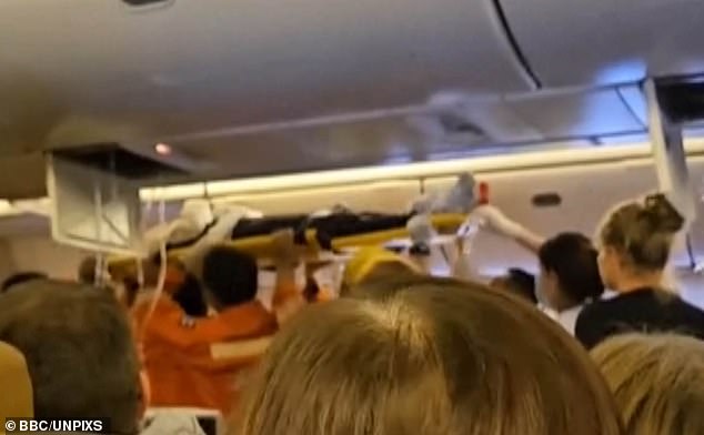 The video shows emergency services removing a passenger from the cabin on a stretcher.