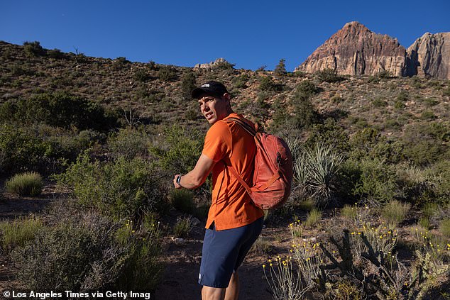 Climber Alex Honnold looks over his shoulder on the approach to the Rainbow Wall in Red Rock Canyon National Conservation Area on Monday, May 13, 2024 in Las Vegas.