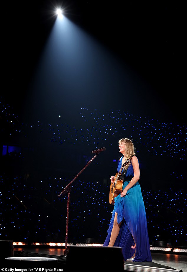 In a TikTok video, Swift could be seen fiddling with the back of her royal blue wrap dress, where her microphone pack would be, while holding her guitar in one hand; Spotted in the same dress in Paris on May 9.