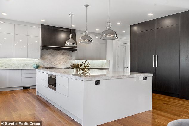 The chef's kitchen features a Sub-Zero refrigerator and marble countertops.