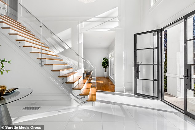 There's a two-story foyer, grand staircase, and glass railings, not to mention soaring ceilings.