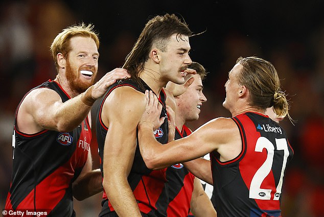 Out of 788 football players and across 18 AFL clubs, 150 of them sport the mullet, like Essendon great man Sam Draper (pictured, centre).