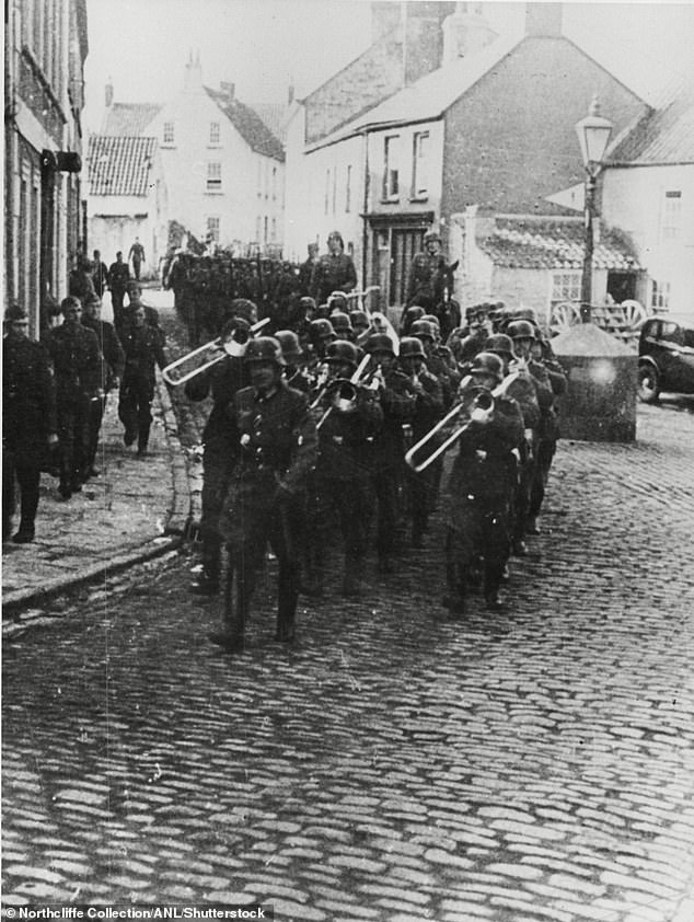 Captives made up of Jews, prisoners of war and some Romani, who were transported to Alderney to build fortifications as part of the German war effort. Pictured: German troops march down Alderney's main street during the occupation.