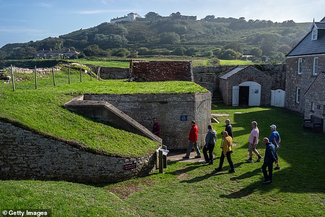 People visit a German bunker on the island of Alderney, Guernsey, where thousands of workers were killed during the Second World War.