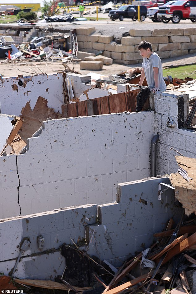 Landyn Ergish, 12, of Greenfield, Iowa, looks into the basement bathroom where she hid with her three siblings and mother while a tornado destroyed their home.