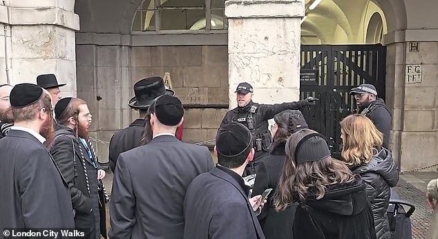 A large group of tourists was caught on camera 'laughing' at the foot of the King's guard