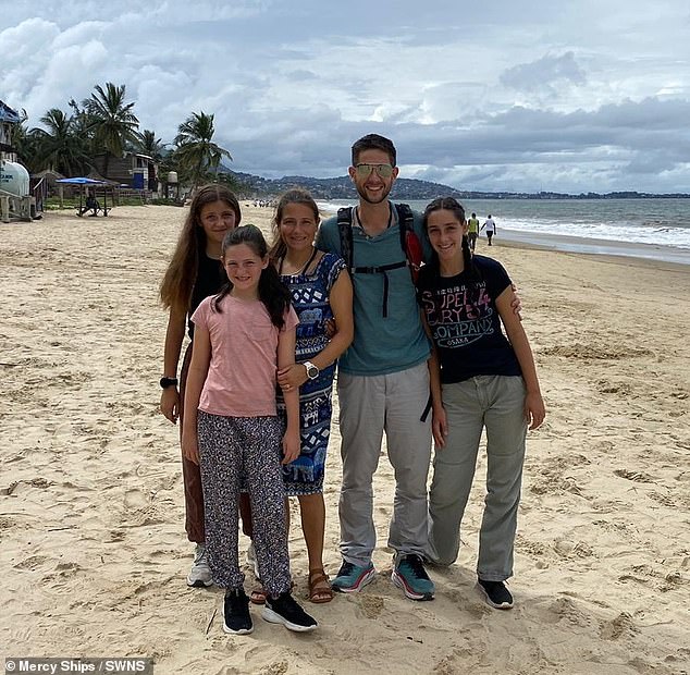 Simon, Amélie and their three children pose together on the beach