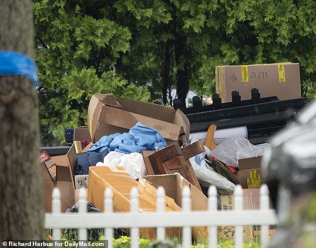 Investigators left huge piles of clothes and belongings scattered on the home's porch in the rain Thursday.