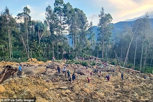 People gather at the site of a landslide in Maip Mulitaka, Enga province, Papua New Guinea, on May 24, 2024.