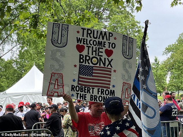 A man holds a 'Robert from the Bronx' welcome Trump to the Bronx sign before the former president's rally.