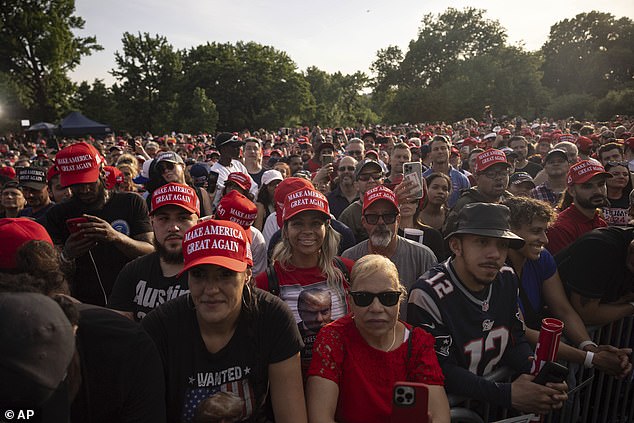 Trump supporters in MAGA hats look toward the podium as the former president holds a rally