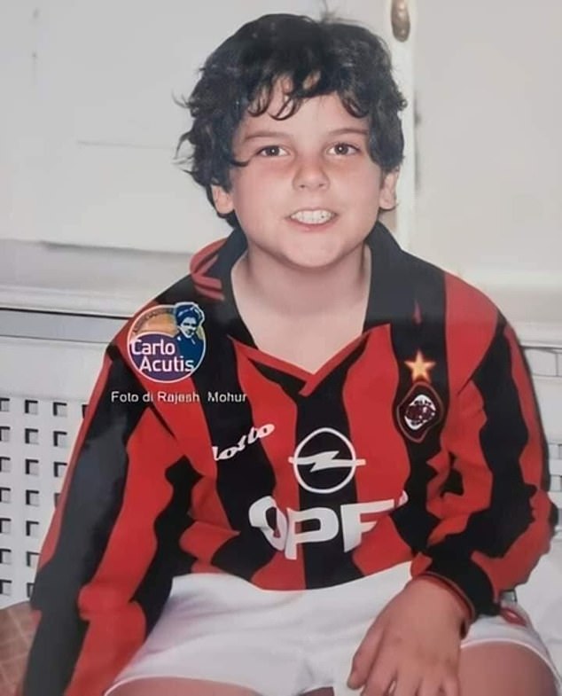 Carlo Acutis photographed smiling at the camera while sporting a 1990s AC Milan home kit.