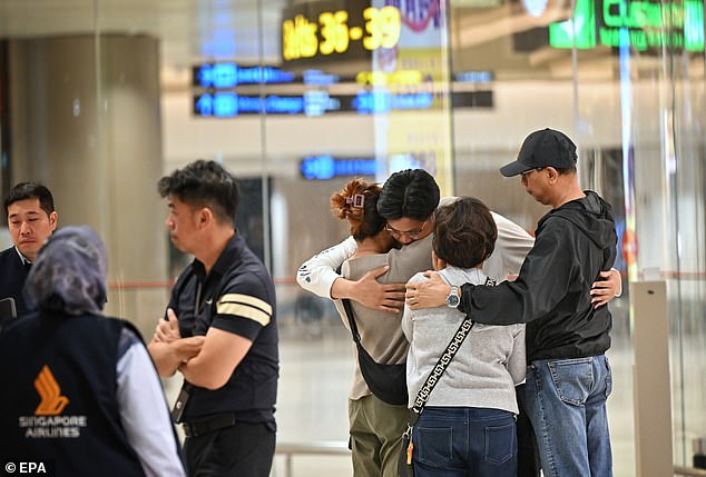 Passengers of Singapore Airlines flight SQ321, which made an emergency landing in Bangkok, greet their families upon arrival at Singapore Changi Airport.