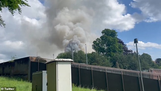 Huge clouds of thick, dark smoke can be seen coming from the building.