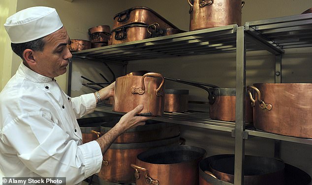 Buckingham Palace head chef Mark Flanagan displays his range of copper frying pans in the kitchen.