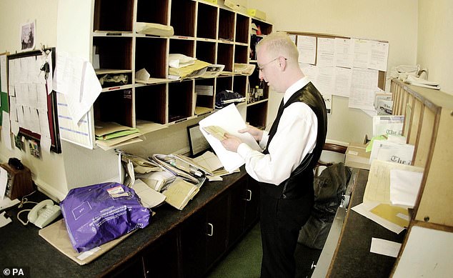 A photograph from 2000 showing a staff member sorting letters in the mailroom.