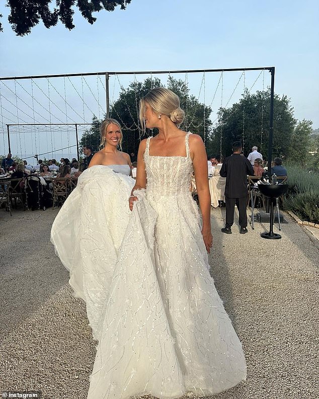 Anna completed her wedding ensemble with a pair of pearl earrings and a bouquet of white roses.