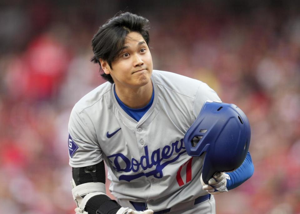 Dodgers star Shohei Ohtani raises his helmet during an at-bat in the first inning against the Reds on Saturday.