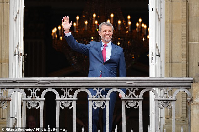 King Frederick looked dapper in a navy suit and red tie as he waved to the crowd from the balcony of Amalienborg Palace today.