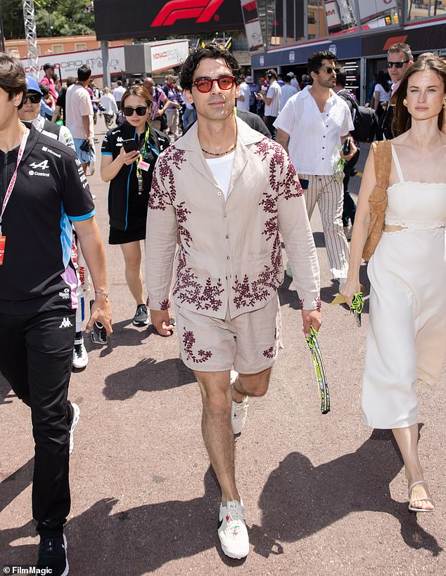 Joe was all smiles as he attended the race wearing a beige printed shirt and matching shorts.