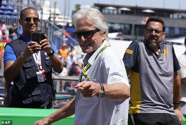 Douglas looked in high spirits as he entered the iconic race's pit lane, dressed in a relaxed, unbuttoned shirt paired with cargo pants.