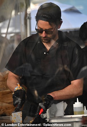 He later donned a baseball cap, worn backwards, and put on gloves while working the grill at the Danny and Coops Cheesesteaks booth.