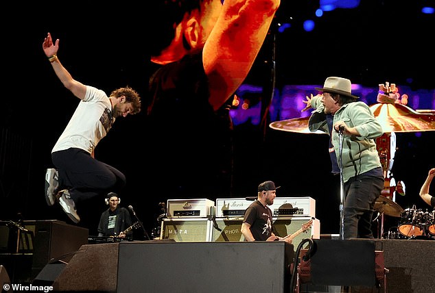 Mimicking the image on his T-shirt, Cooper showed off his rock-inspired high jump while performing singer-songwriter Neil Young's Rockin' in the Free World with Vedder and the band.