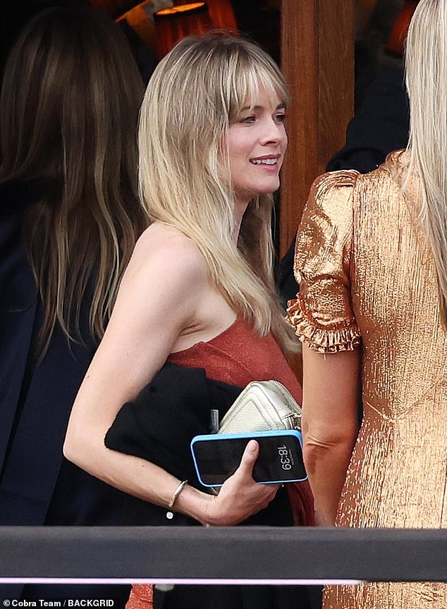 The mother-of-one held her mobile phone and off-white handbag as she waited to board the boat.