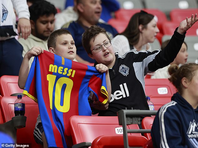 A young soccer fan holds up a Lionel Messi jersey before a match at BC Place in Vancouver.