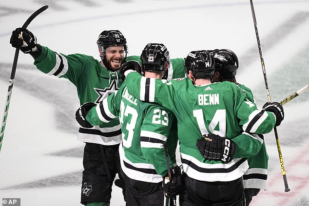 Dallas Stars' Tyler Seguin (91), Esa Lindell (23), Jamie Benn (14) and Miro Heiskanen (4) celebrate after Lindell scored an empty-net goal to seal Saturday's victory over Edmonton.