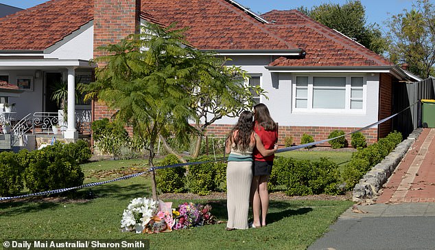 In the photo, two young women lay a floral tribute at Petelczyc's home on Berkley Street.