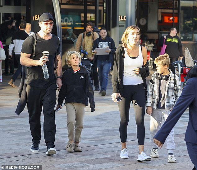 Allowing an airport worker to carry his family's luggage, Chris carried only a small black backpack as he juggled bottles of water and juice, as well as a to-go cup of coffee in his hands.