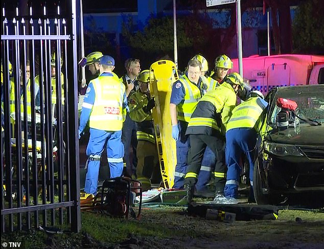 Mr Duong and his daughter Haili died at the scene (pictured, paramedics and doctors working to free passengers from the sedan)