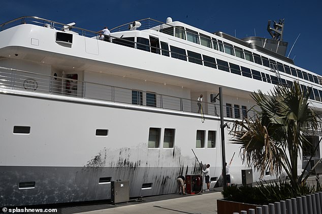 The workers immediately set about cleaning the yacht's paint.