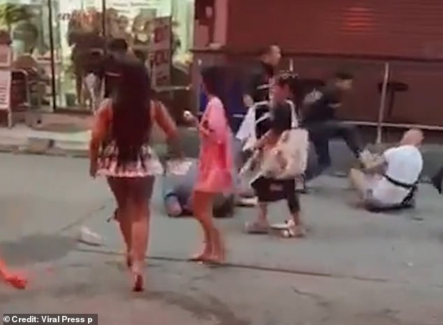 The man in white was pushed to the ground, where the bouncers began to beat him.