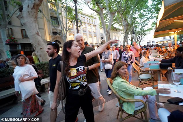 Protesters shout at surprised tourists enjoying dinner and drinks in Palma