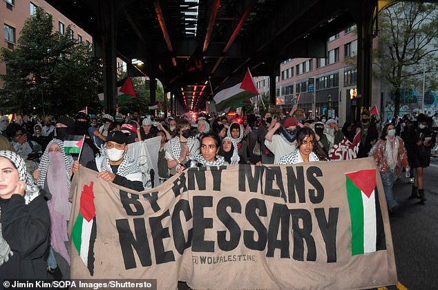 Pro-Palestinian protesters march holding a banner expressing their opinion in the Astoria neighborhood of Queens, New York, in mid-May.