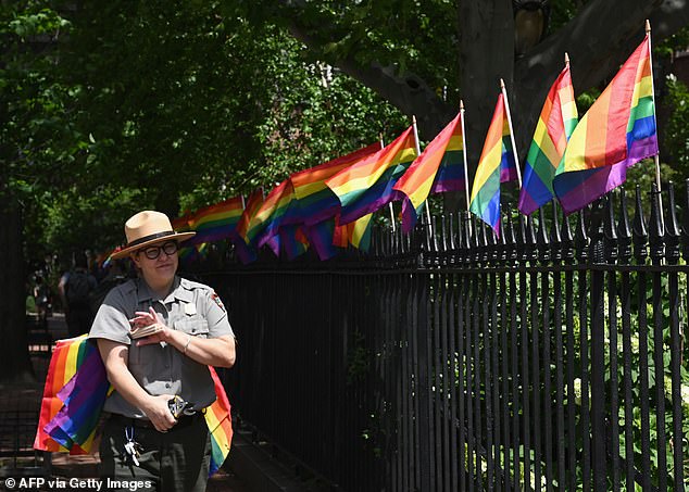 Pictured: A park ranger places rainbow flags at Stonewall National Monument, the first national LGBTQ monument, dedicated to the birthplace of the modern lesbian, gay, bisexual, transgender and queer civil rights movement on June 4, 2019 in La New York City.