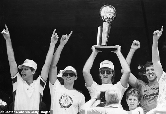 Carlisle (second left) and Walton (right) celebrate the 1986 Celtics championship together.