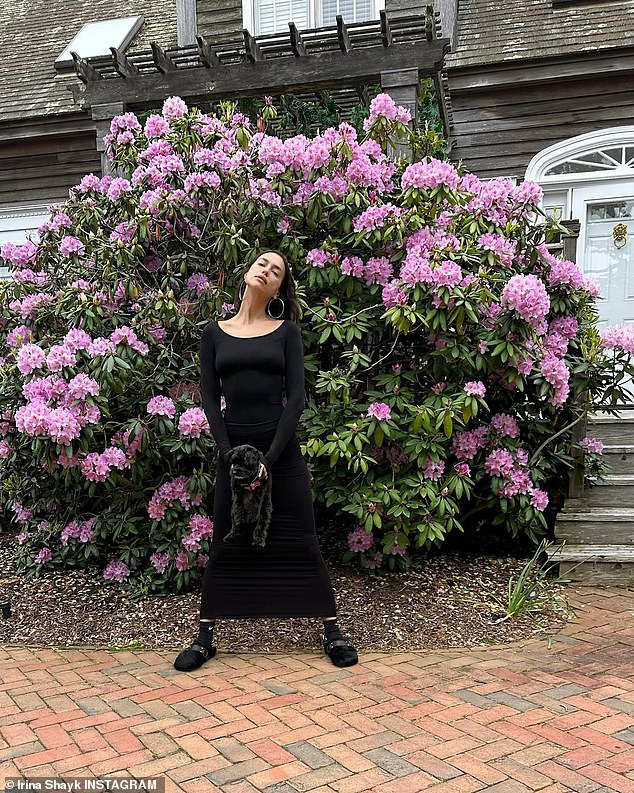 Irina also posed in front of a large purple flower bush in another fun photo.