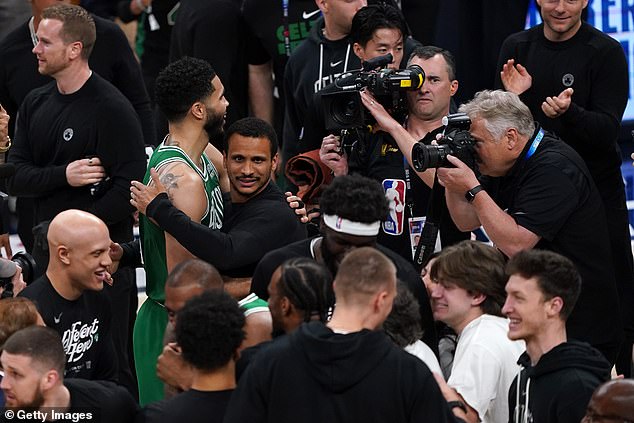 Celtics coach Joe Mazzulla and Jayson Tatum hug after the game on the court.