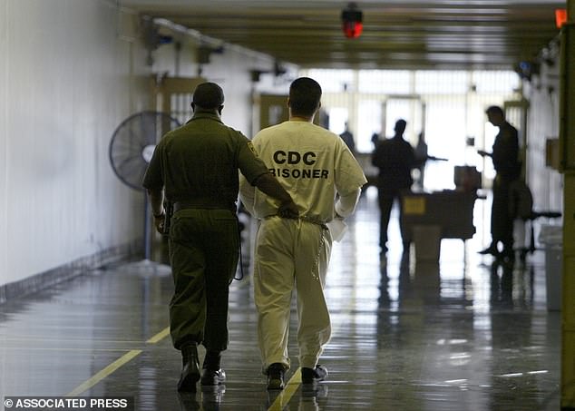 A prison guard escorts a prisoner down a hallway at the California Medical Center in Vacaville, California (file photo)