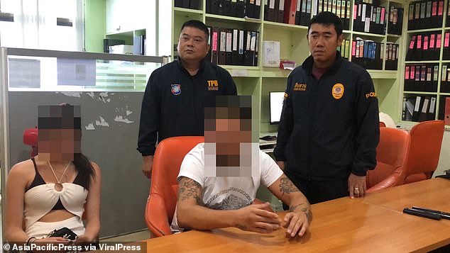 The British man appears detained with the Thai police.