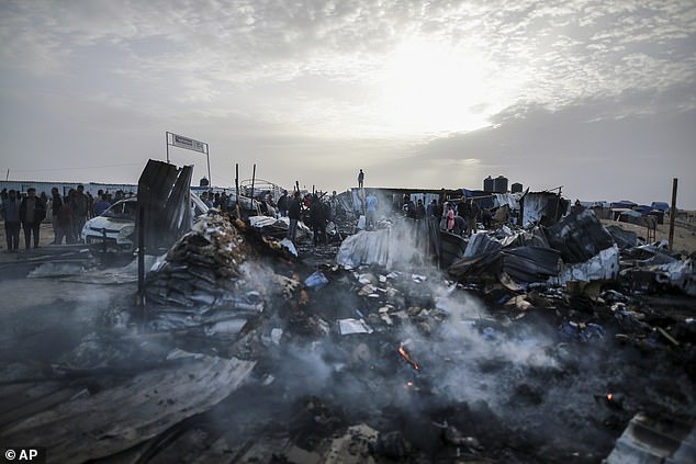 Palestinians watch the destruction after an Israeli attack where displaced people were staying in Rafah, Gaza Strip, Monday, May 27, 2024.