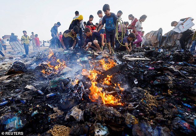 Palestinians search for food among the burned rubble after an Israeli attack