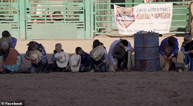 The young cowboys are shown holding their hat and kneeling on the ground in prayer for Levi.