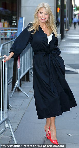 She added some color to her look of the day with a pair of bright red heels.