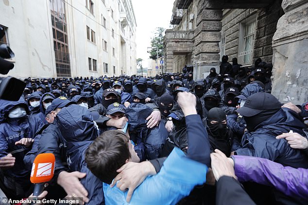 Demonstrators, who were organizing a protest, clash with police officers as they try to breach the security perimeter of the Georgian Parliament building.