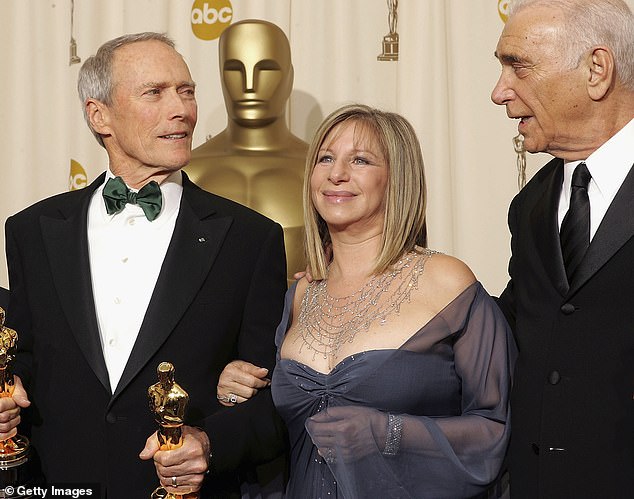 Clint, far left, held by Barbra Streisand after winning for Million Dollar Baby along with his producer Al, far right.