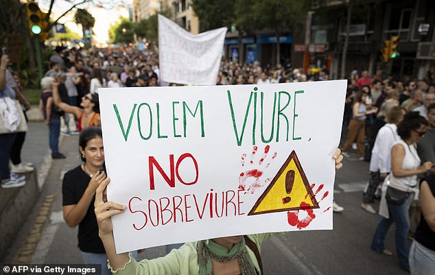 Protesters hold a sign that says 